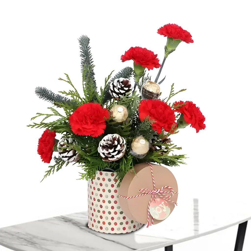 Joy Christmas Flower Box with fresh red carnations, seasonal greenery, and rustic pine cones